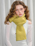 Model wearing yellow knitted scarf with textured pattern