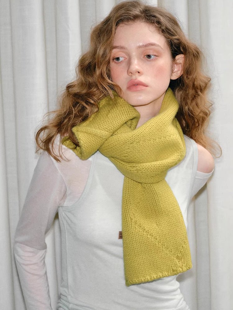 Model wearing yellow knitted scarf with button closure