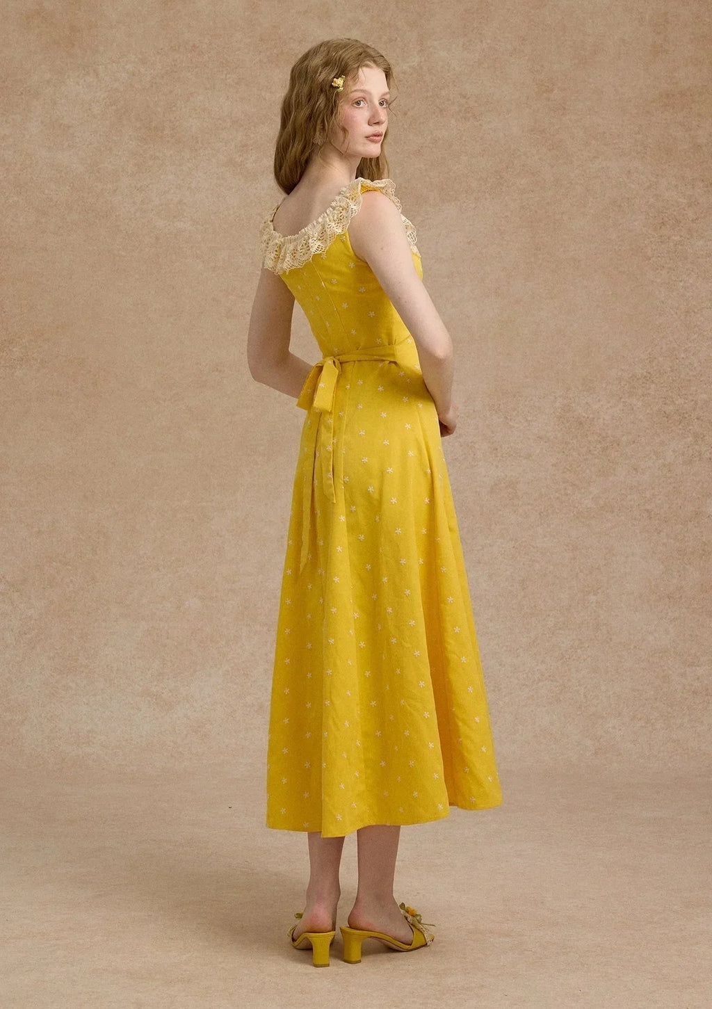 Full view of a yellow A-line maxi dress with a gathered bust and floral pattern