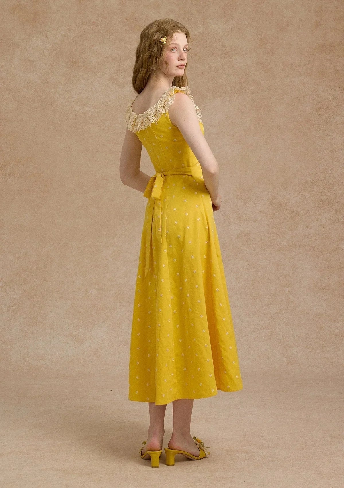 Full view of a yellow A-line maxi dress with a gathered bust and floral pattern