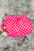 Pink checkered athletic shorts displayed on a faux fur rug
