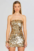 Woman wearing a gold sequined strapless mini dress