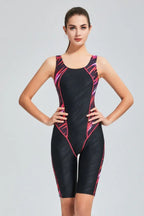 Woman wearing a black and pink patterned full-coverage athletic swimsuit