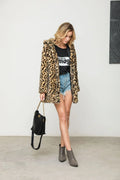 Woman posing with a leopard print faux fur coat and a handbag