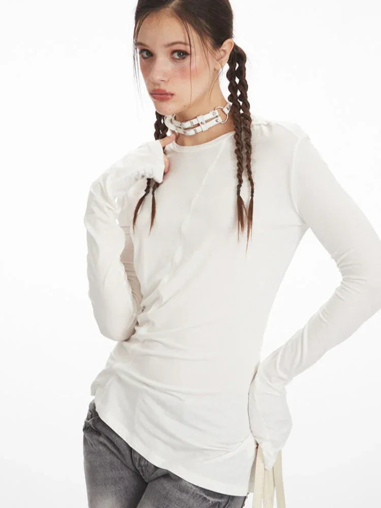 Model showing off the neckline and sleeves of a white long sleeve top.