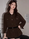 Woman wearing a brown corduroy oversized shirt with a collared neckline and button-down front.
