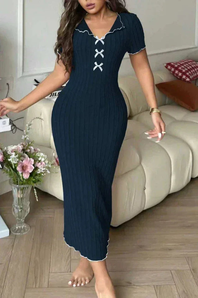 Woman wearing a dark blue ribbed knit midi dress with white contrast trim and a lace-up neckline detail.