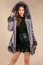 Woman wearing a grey hooded faux fur coat with fur trim