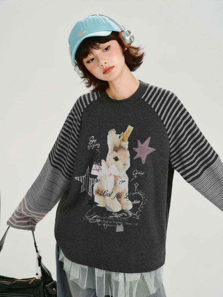 Woman wearing a dark grey long sleeve t-shirt with a graphic print of a bunny and stars.
