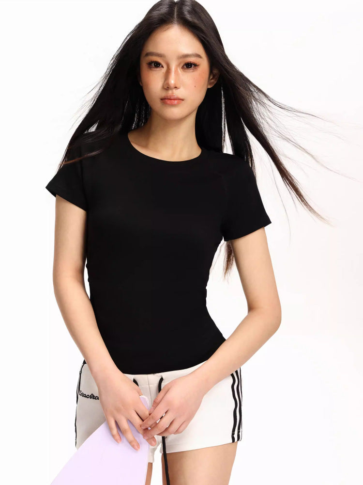 Woman wearing a black fitted short-sleeve t-shirt and white athletic shorts