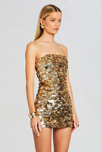 Side view of a woman in a gold sequined strapless dress
