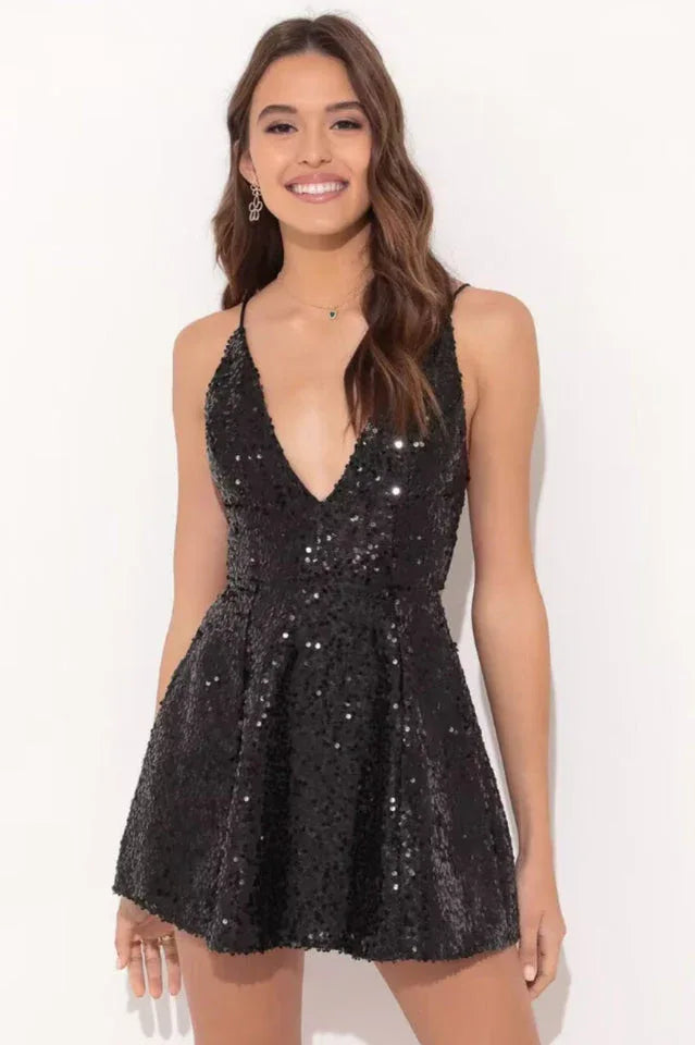 Woman wearing a black sequined mini dress with spaghetti straps and a deep V-neck.