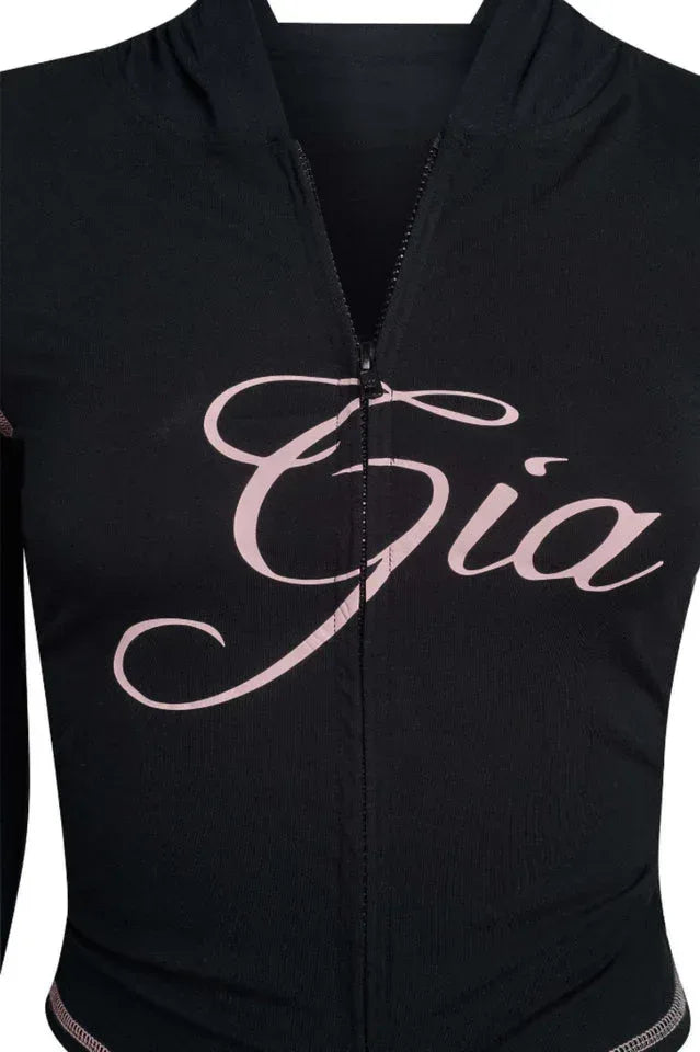 Close-up of black jacket with pink embroidered text and zipper