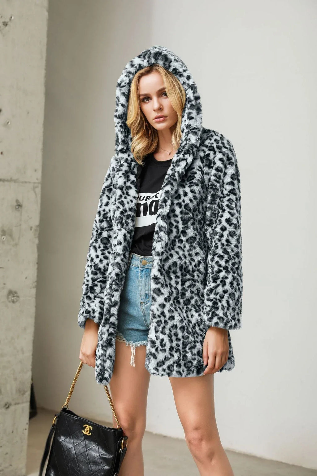 Woman in a black and white leopard print hooded faux fur coat
