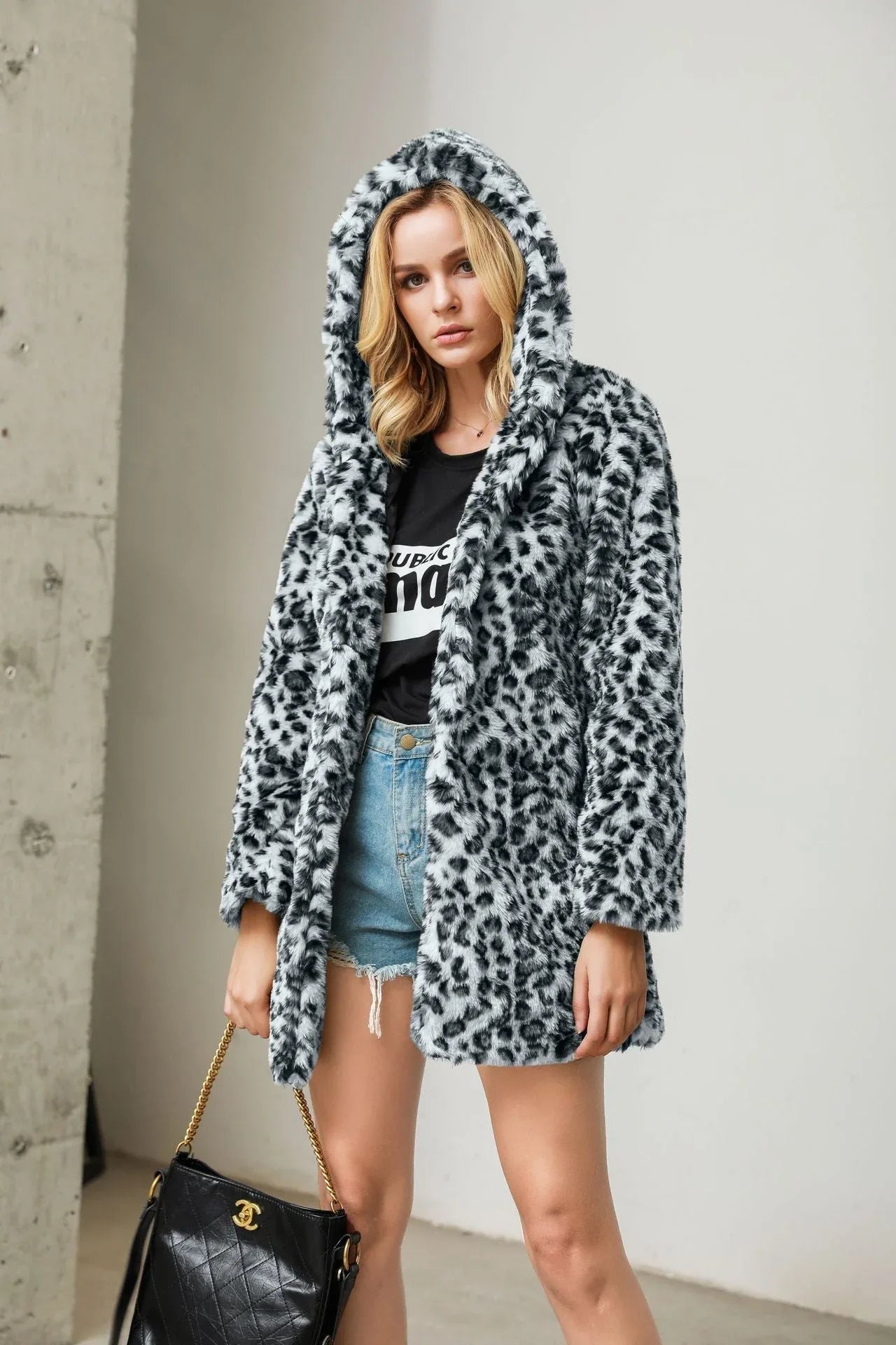 Woman in a black and white leopard print hooded faux fur coat