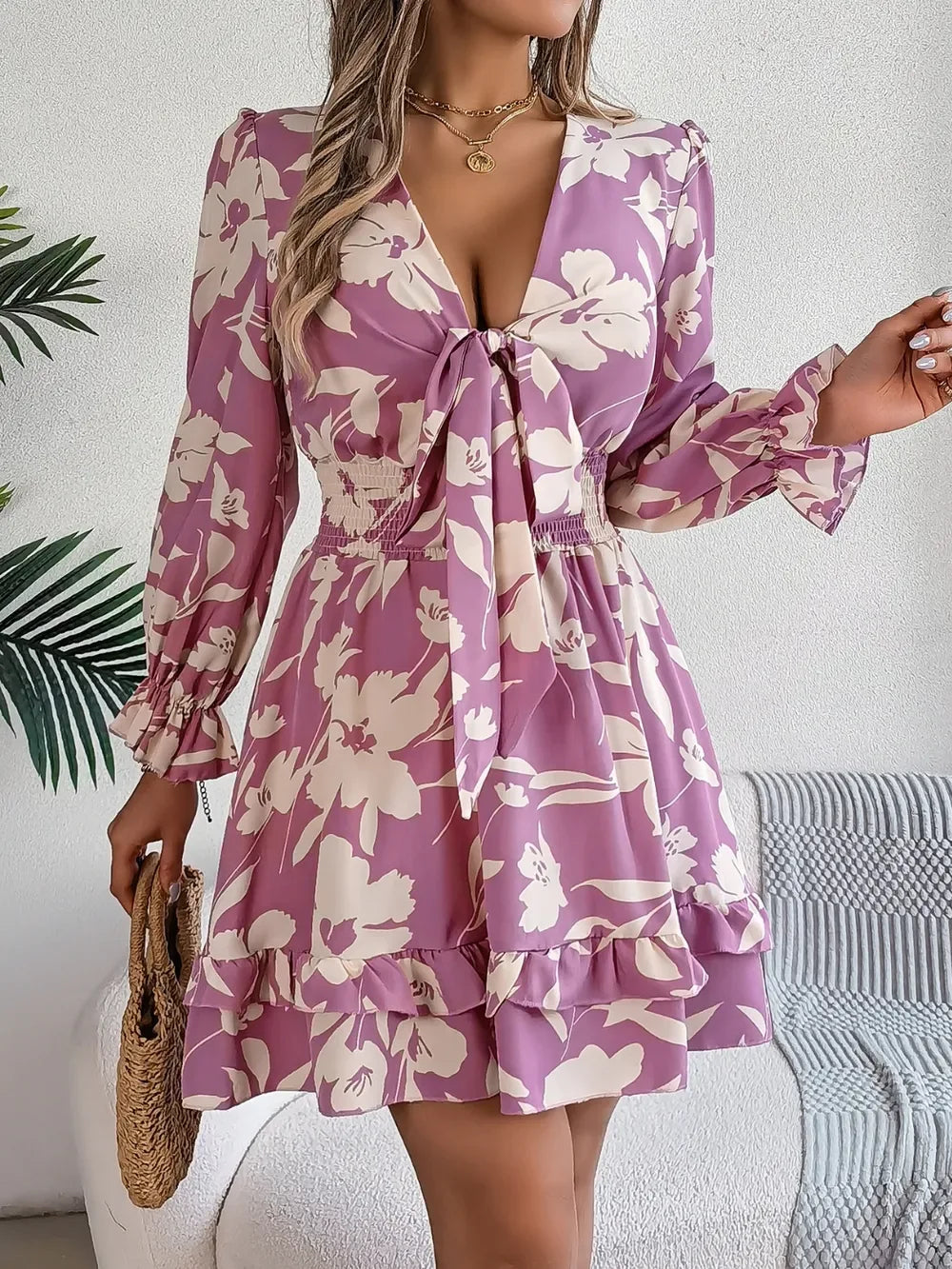 Woman wearing a mauve purple floral tie-front mini dress