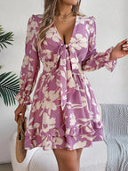Woman wearing a mauve purple floral tie-front mini dress