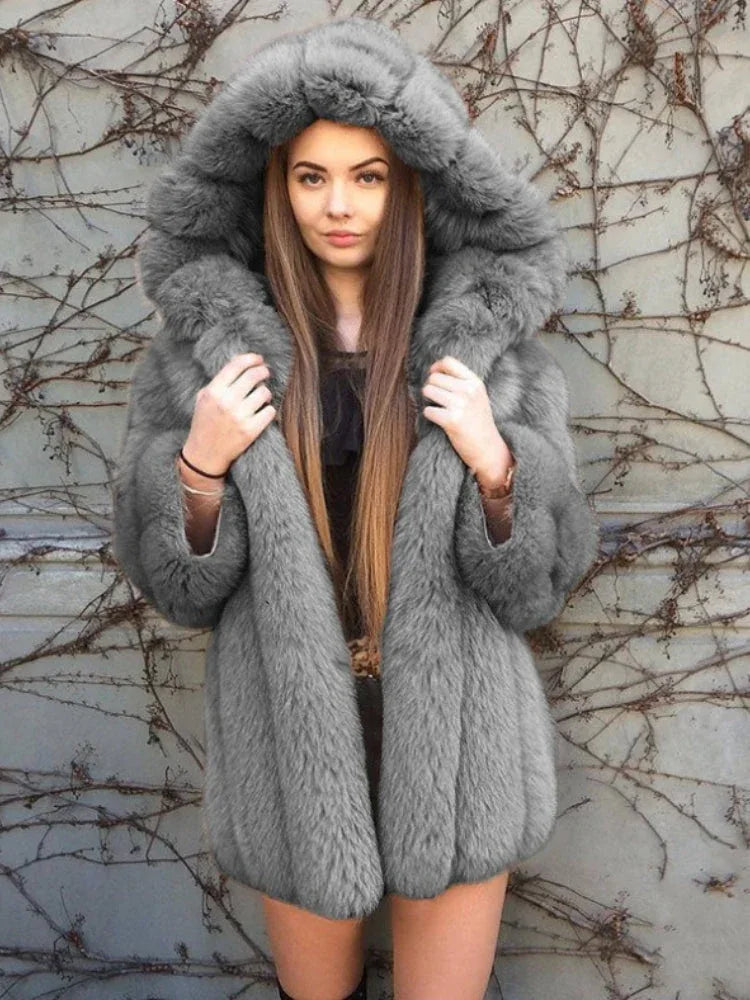 Woman wearing a grey hooded faux fur coat.
