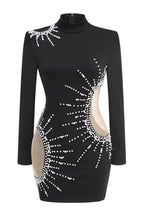 Model posing in a black, embellished mini dress with a high neckline and long sleeves