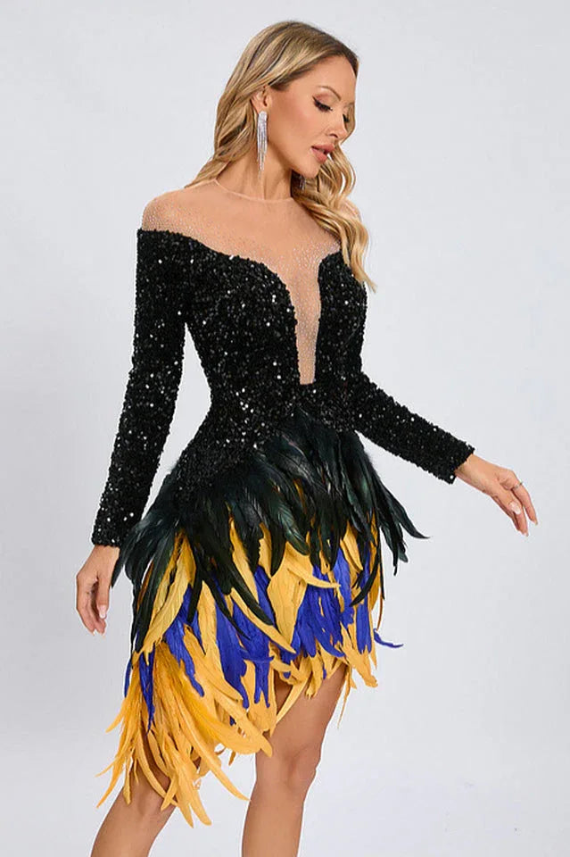 Full body shot of a woman modeling a black sequined dress with long sleeves and a multi-colored feather skirt.