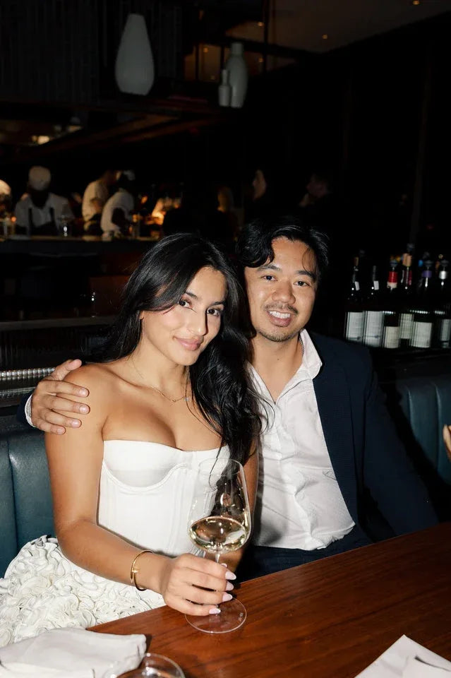 Woman in a white strapless corset dress with a ruffled skirt at a table