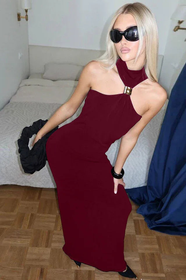Woman in a burgundy halter neck dress posing with a black accessory.