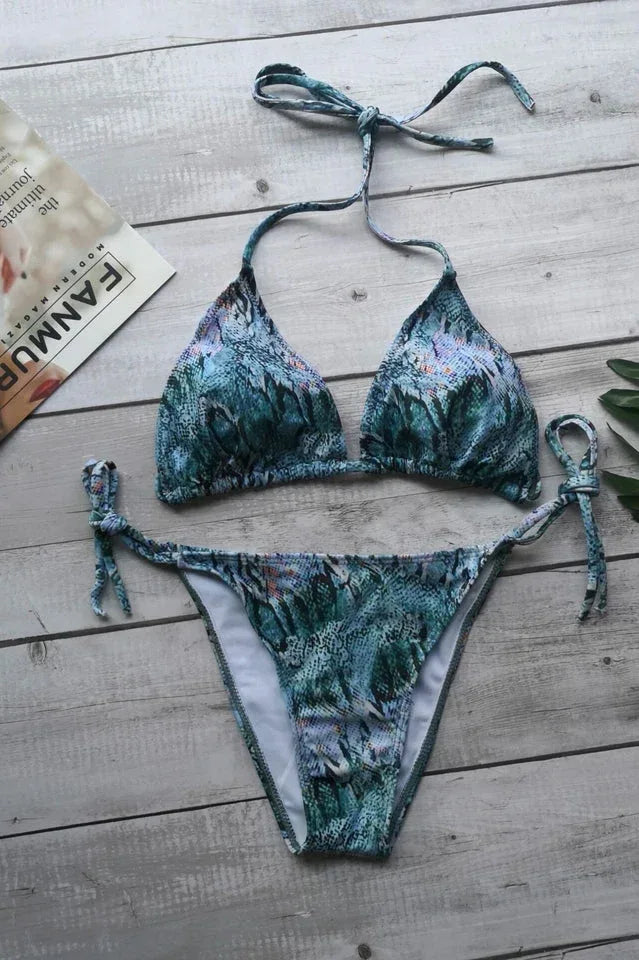Flat lay of a blue and green snake print triangle bikini set