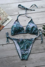 Flat lay of a blue and green snake print triangle bikini set