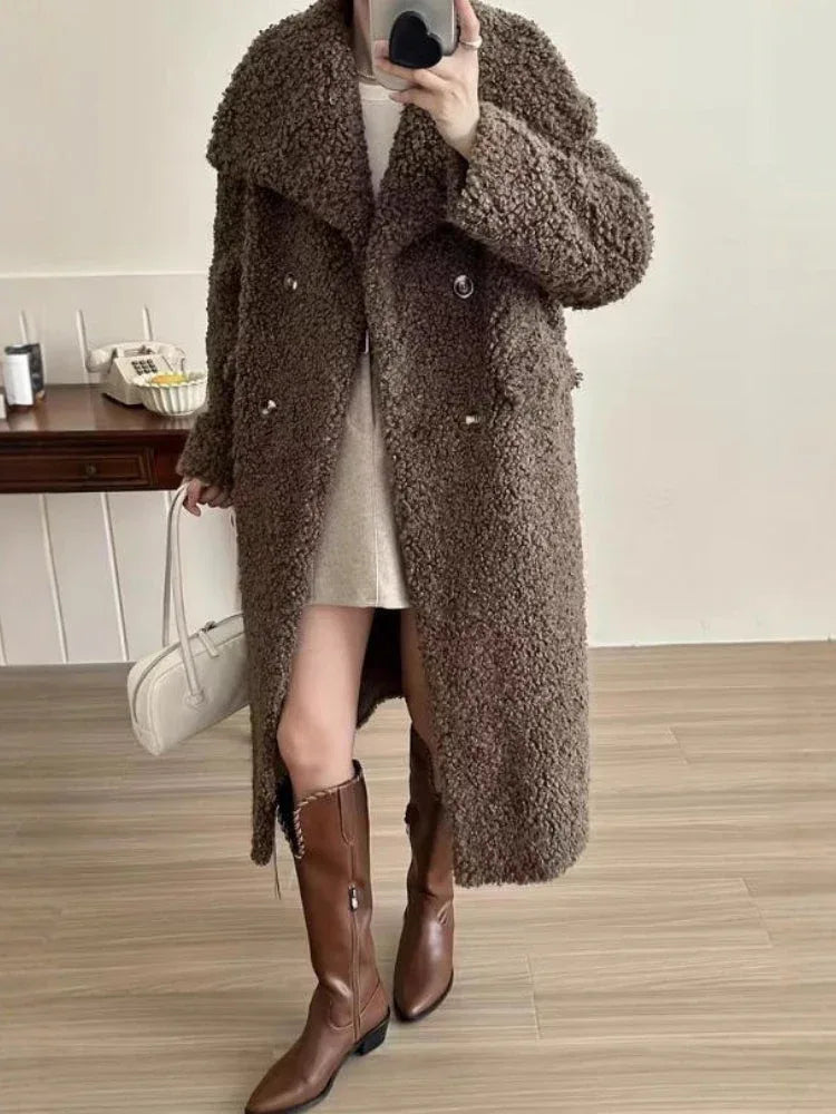 Woman wearing a long brown textured fleece coat with a double-breasted closure and notch lapels.
