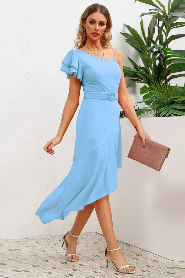Full shot of a woman in a light blue one-shoulder dress with ruffled sleeve and asymmetrical skirt