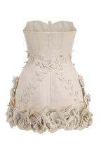 Close-up of the lace-up detail on a cream corset dress worn by a woman