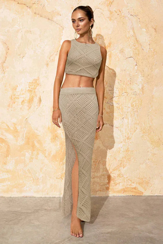 Close-up of a woman wearing a beige knit crop top and a matching beige knit maxi skirt with a thigh-high slit, front view.