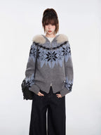 Woman in a grey knit zip-up sweater with a Nordic-inspired pattern and fluffy hood.