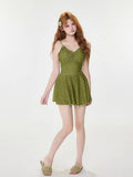 Full body shot of a woman in a green paisley print one-piece swimsuit with shorts