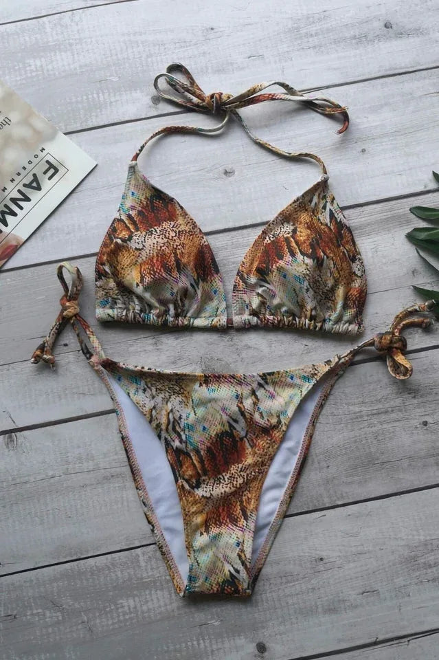 Tan and orange snakeskin print bikini set on a wooden surface