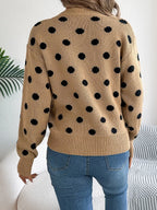 Back view of a woman in a tan polka dot sweater and blue jeans.