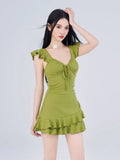Model posing in a lime green ruffled mini dress with a textured fabric, suitable for casual or resort occasions.