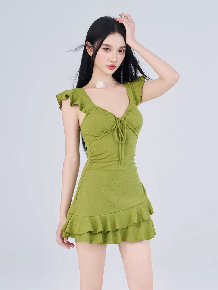 Model posing in a lime green ruffled mini dress with a textured fabric, suitable for casual or resort occasions.