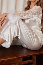 Detail shot of the lace sleeves and feather trim on a white satin robe