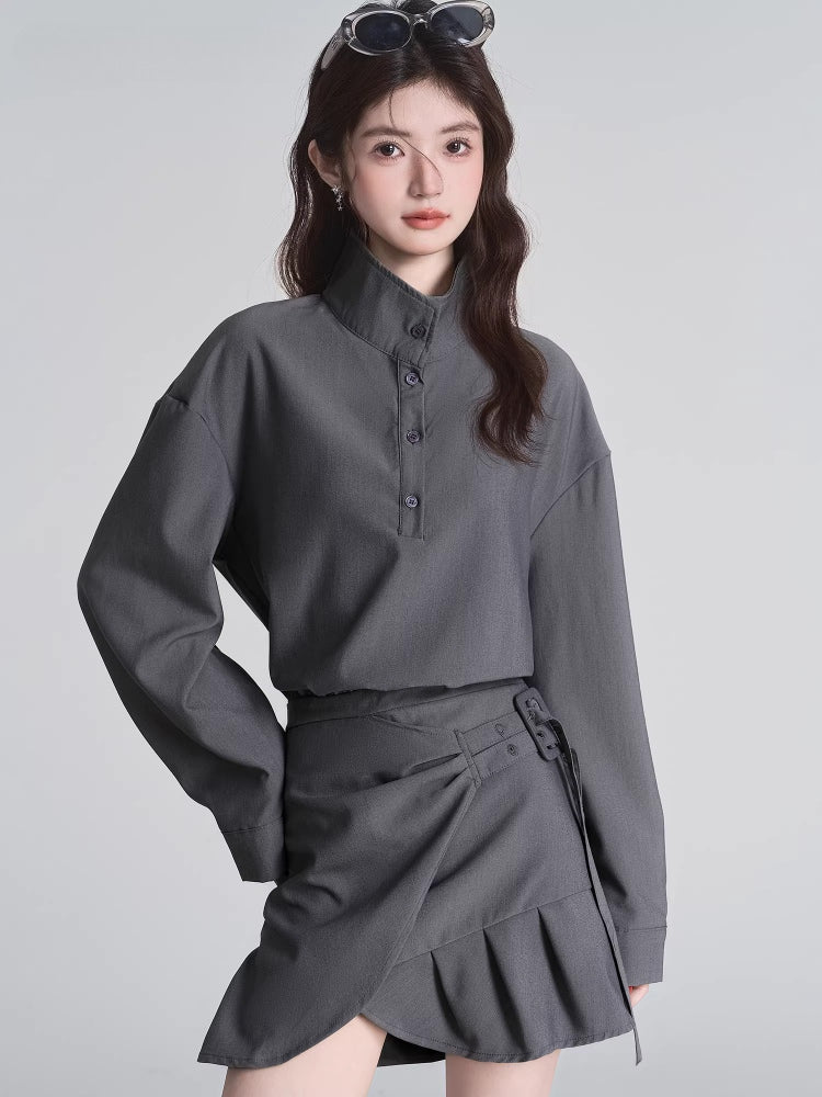 Close-up of a woman wearing a grey collared shirt with buttons