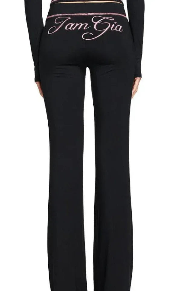 Model wearing a black long-sleeve cropped zip-up jacket and black flared pants
