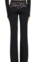 Model wearing a black long-sleeve cropped zip-up jacket and black flared pants
