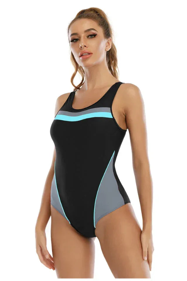 Woman wearing a black athletic swimsuit with color block panels