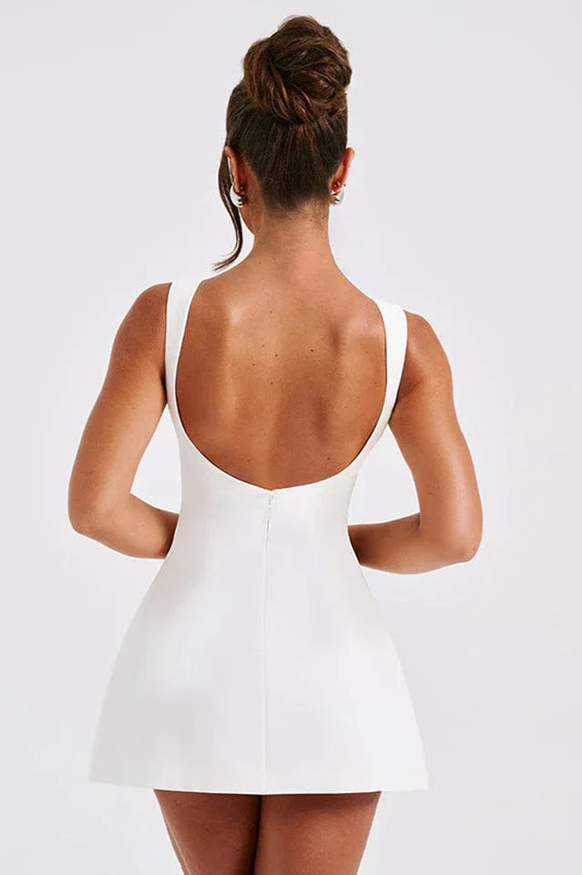 side view of a woman in a red mini dress with a square neckline and thin straps