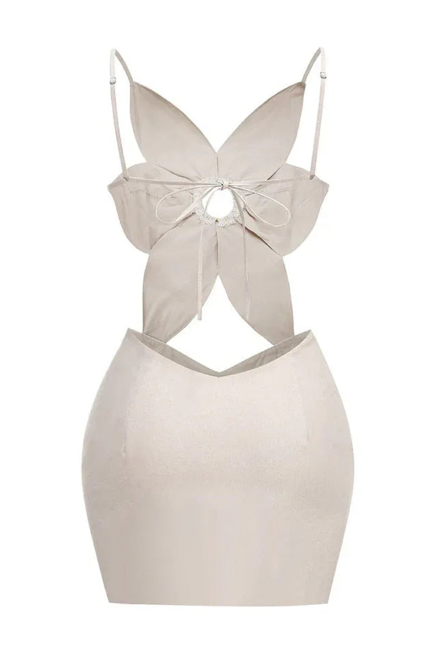 Back view of a beige linen blend dress with a flower-shaped bodice, cut-out detail, and back tie closure.