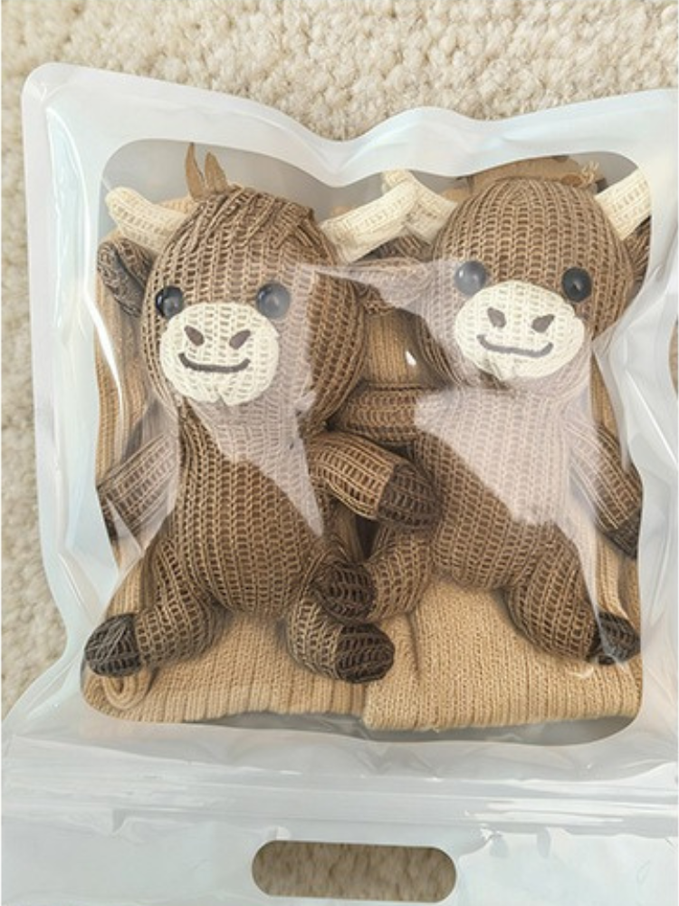 Pair of beige ribbed knit crew socks with non-slip grips on the sole, showcasing the ribbed texture.