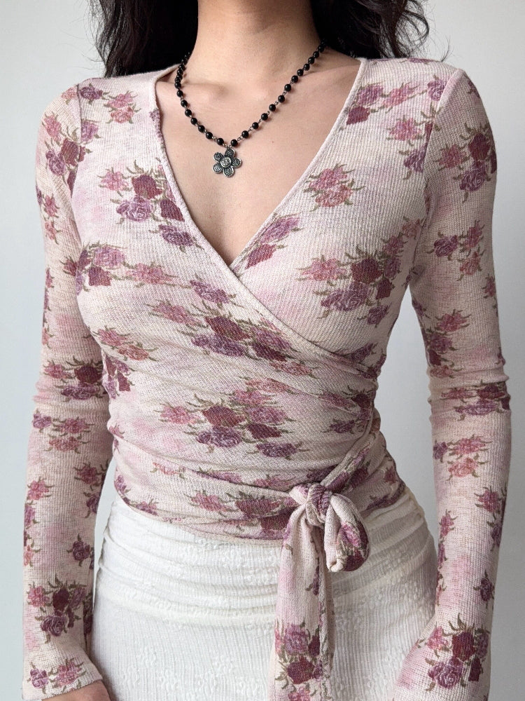 Front view of a woman in a fitted floral wrap top with a tie at the waist.
