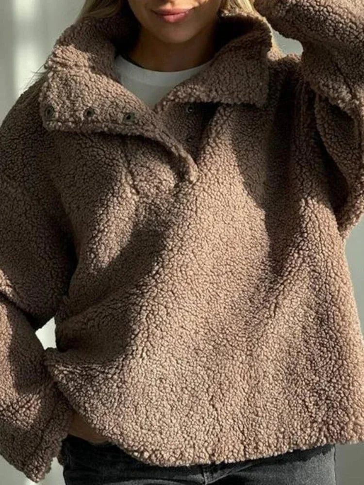 Close-up of the textured fleece fabric and button details on a brown pullover.
