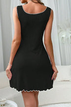 Close-up of the neckline of a black ribbed knit chemise with white bow