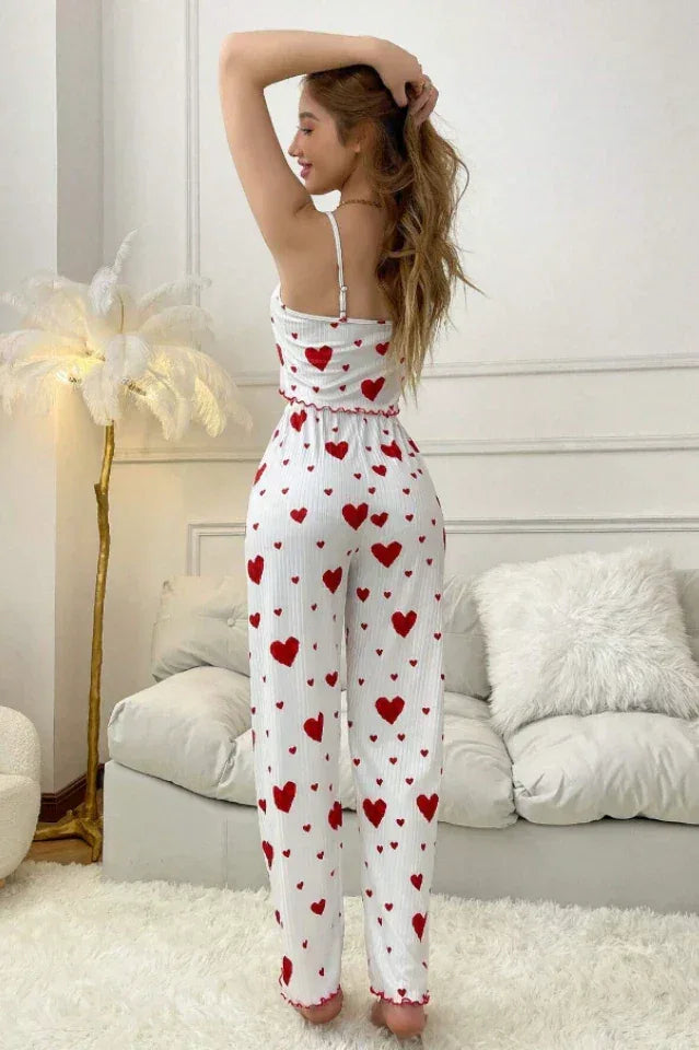 Back view of a woman in a white and red heart print pajama set with wide-leg pants.